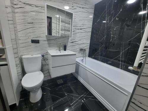 巴亚马雷Apartament Coco的浴室配有卫生间、浴缸和水槽。