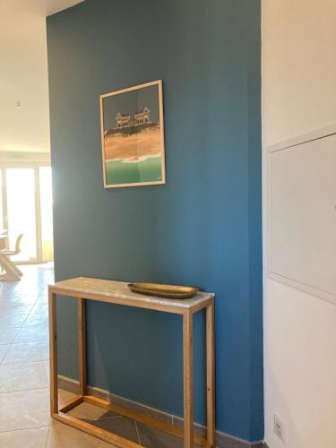 比斯卡罗斯Superbe appartement rénové, parking et terrasse的蓝色墙壁的房间里一张桌子