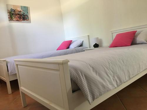 维琪奥港Les oliviers de Murateddu (Maison individuelle)的一间卧室配有两张带红白色枕头的床