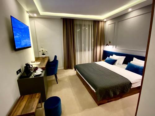 上米拉诺瓦茨IG Hotel的一间卧室配有一张床、一张书桌和一台电视。