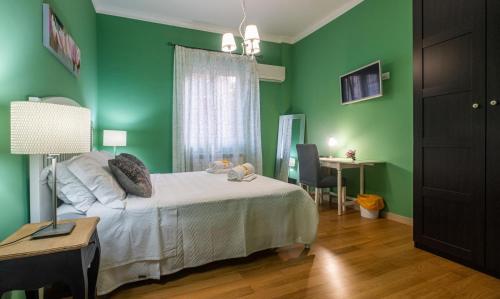 巴勒莫LE STANZE DI LUCA的一间卧室设有绿色的墙壁、一张床和一张书桌