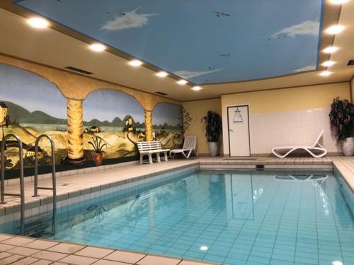 瓦尔兴湖Ferienwohnung Royal Walchensee的一座拥有壁画的酒店的大型游泳池
