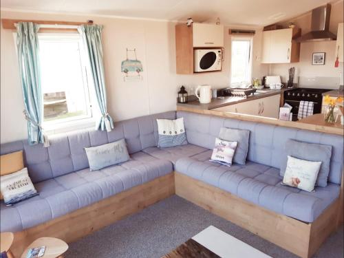 本布里奇Bliss Beach Lodge的客厅设有蓝色沙发,厨房设有
