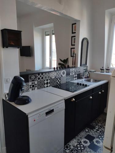 圣让-德吕兹Appartement pied de plage的厨房的柜台铺有黑白瓷砖