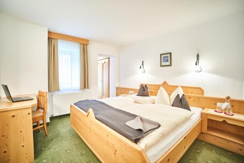 洛伊塔施豪斯索恩维戈酒店的一间卧室配有一张大木床和书桌