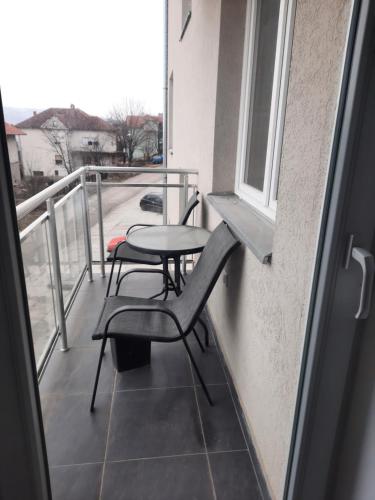 索科矿泉村Nadja i Emili的阳台配有桌椅和窗户。