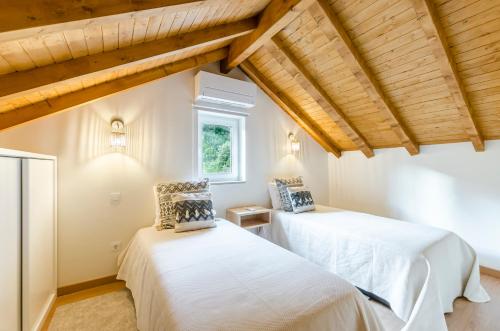 吉尔斯Chalet Villas Gerês的配有木天花板的客房设有两张床。