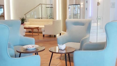 波利克罗诺Akrogiali Exclusive Hotel (Adults Only)的客厅配有蓝色的椅子和桌子