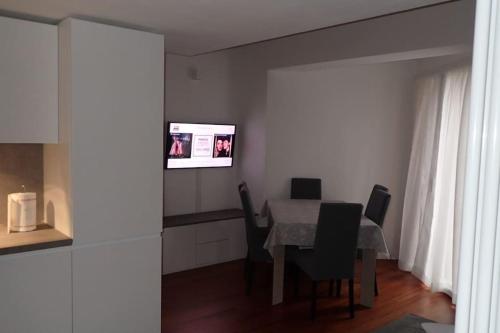 兰佐丁泰尔维Incantevole appartamento con piscina e vista monti的一间带桌椅和电视的用餐室