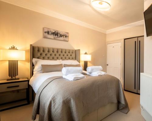 鲍内斯温德米尔Edge Mere Apartment, Bowness-on-Windermere的一间卧室配有一张大床和两条毛巾