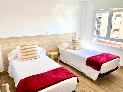 诺哈Apartamento Arenal ATICO的一间卧室设有两张床和窗户。