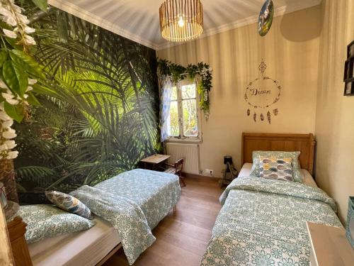 谢尔河畔努瓦耶Le Clos des Trois Provinces, Zoo de Beauval的一间卧室设有两张床和植物墙