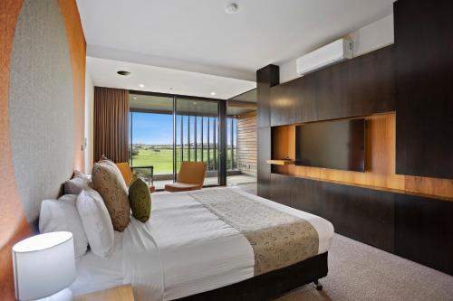 芬戈百伯穆拉林克度假村的一间卧室配有一张大床和电视