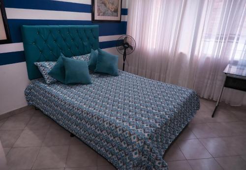 麦德林Casa La Palma Habitación Cielo的一间卧室配有一张带绿色床头板的床