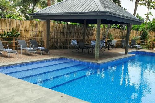 克罗托格Ramada Suites By Wyndham Seafront Coral Coast的一个带凉亭和桌椅的游泳池