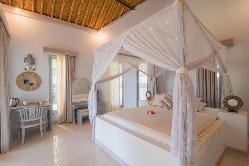 艾湄湾Salt Resort & Spa的一间卧室配有一张天蓬床和一张书桌
