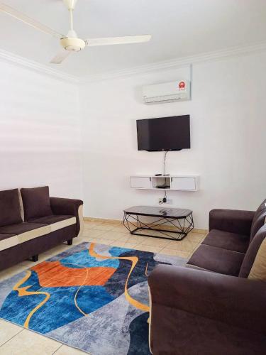 莎阿南MZ homestay的客厅配有两张沙发和一台电视机