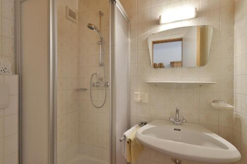 迈尔霍芬特劳德尔旅馆的白色的浴室设有水槽和淋浴。