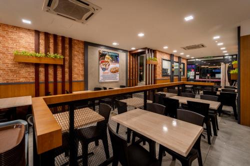 吉隆坡East Riverine Boutique Hotel的一间带桌椅的餐厅和一间酒吧