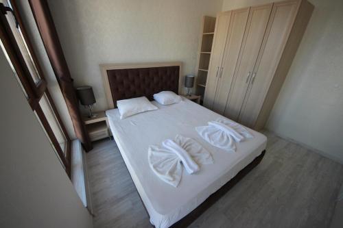 布尔加斯Menada Harmony Suites X的一间卧室配有带白色床单和枕头的床。