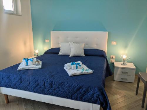阿谢亚Il Giglio Marino Cilento Residence by ElodeaGroup的一间卧室配有蓝色的床和2条毛巾