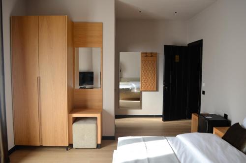 地拉那N'Peze Hotel的一间卧室配有床、橱柜和镜子