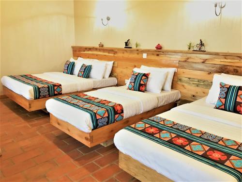 波特尔堡Kaswa Lodge的带木墙的客房内的三张床