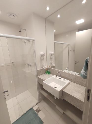坎普斯戈伊塔卡济斯Apart Hotel - América Residence Campos dos Goytacazes的白色的浴室设有水槽和淋浴。