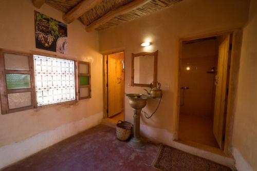 凯拉Kasbah Itran的一间带水槽和镜子的浴室以及窗户。