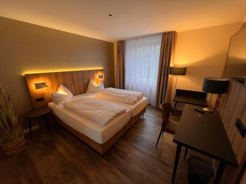 汉诺威艾玛迪斯餐厅酒店的酒店客房设有一张大床和一张书桌。