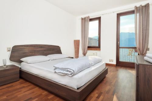 马尔切西内Lake Front Casa Christina的一间卧室配有一张带白色床单和窗户的床。