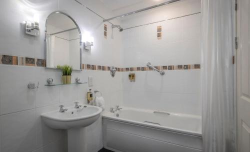 基拉尼格林尼格河畔公寓酒店的白色的浴室设有水槽和浴缸。