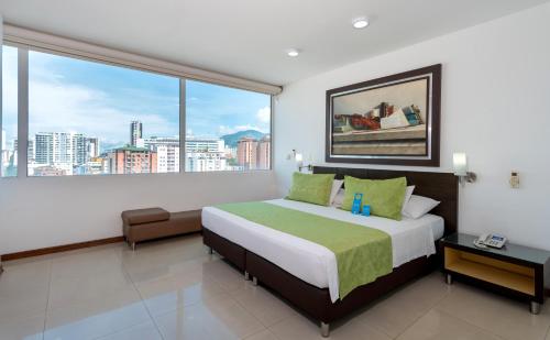 布卡拉曼加奇卡莫查酒店的一间卧室设有一张大床和大窗户