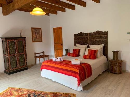 FénolsBrin de Cocagne的一间卧室配有一张带红色枕头的大床