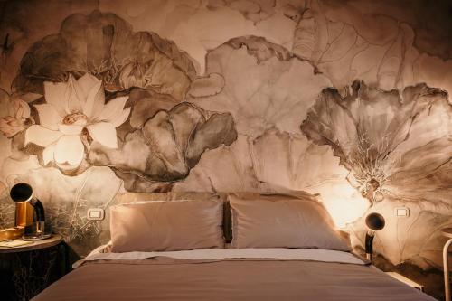 阿巴迪亚圣萨尔瓦托雷B&B La Castellina的卧室配有一张挂着花壁画的床。