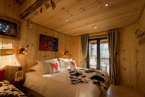 Fournet-BlancherocheDomaine de l'Authentique Cabanes dans les arbres的卧室配有一张床铺,位于带木墙的房间内