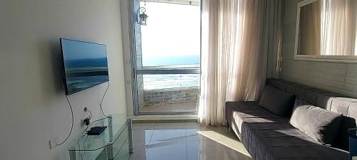 巴特亚姆Apart Hotel TLV/Bat Yam Beach Front 1207的带沙发和大窗户的客厅