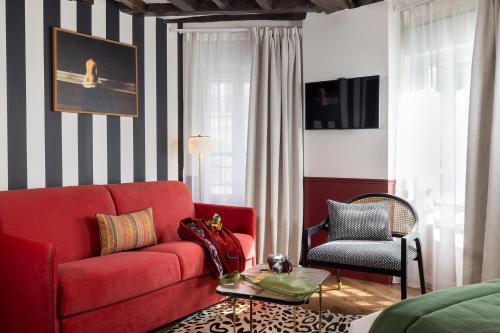 巴黎Hotel Louis II的客厅配有红色的沙发和椅子