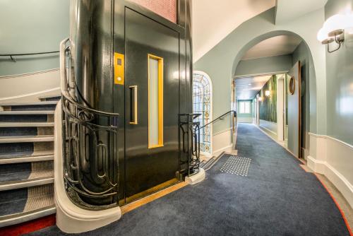 巴黎Holiday Inn Paris - Gare de Lyon Bastille, an IHG Hotel的走廊上设有黑色的门和楼梯