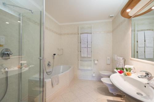 卡斯特尔罗托狼之酒店的带浴缸、水槽和淋浴的浴室