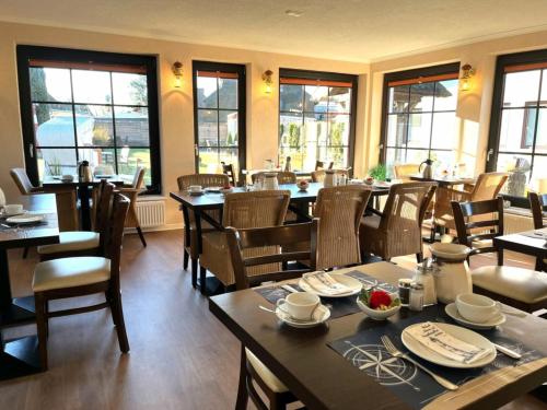 普雷罗Pension Windrose的用餐室设有桌椅和窗户。