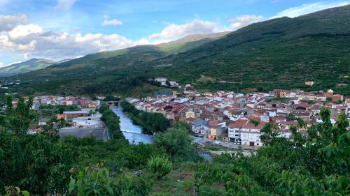 纳瓦孔塞霍LA PARRA - Casa Rural en el Valle del Jerte的山谷中的小镇,有河流和山脉