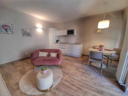 坎诺比奥Alessia Home的客厅配有粉红色的沙发和桌子