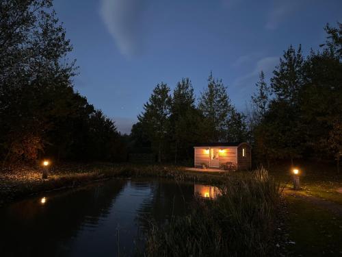 约克Luxury Shepherds Hut - The Moorhen by the lake的池塘中央的小屋