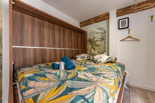 蒙托邦Chez Ingres - Le Nid - Joyau caché en centre ville的一间卧室配有一张大床和木制床头板