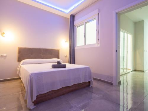 福恩吉罗拉Luxury Suite Fuengirola 1的一间带床的卧室,位于带窗户的房间内