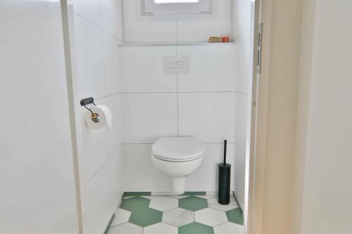德文格洛Buitenlede 7 - Suite M的设有带卫生间的浴室,铺有绿色和白色的地板。