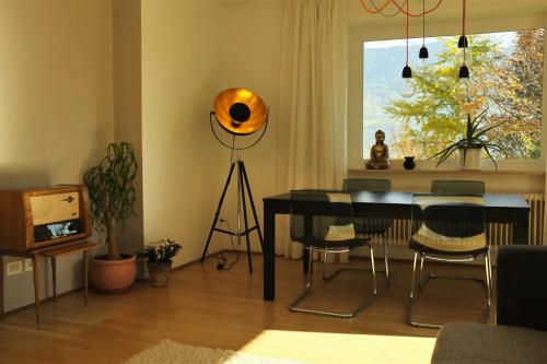 马伦格La Vista - Apartment mit Traumblick & Garten的客厅配有桌椅和窗户。