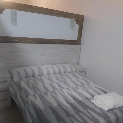 阿尔迪努瓦德拉夫拉Apartamento el cuco的一间卧室配有带条纹棉被的床和窗户