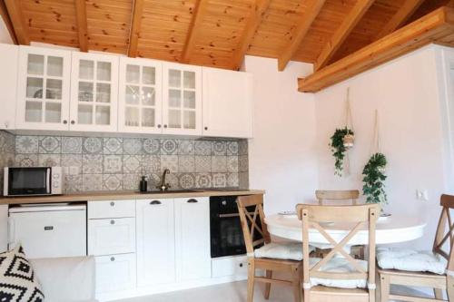 萨莫色雷斯Samothrakis Michelangelo 301的厨房配有白色橱柜和桌椅